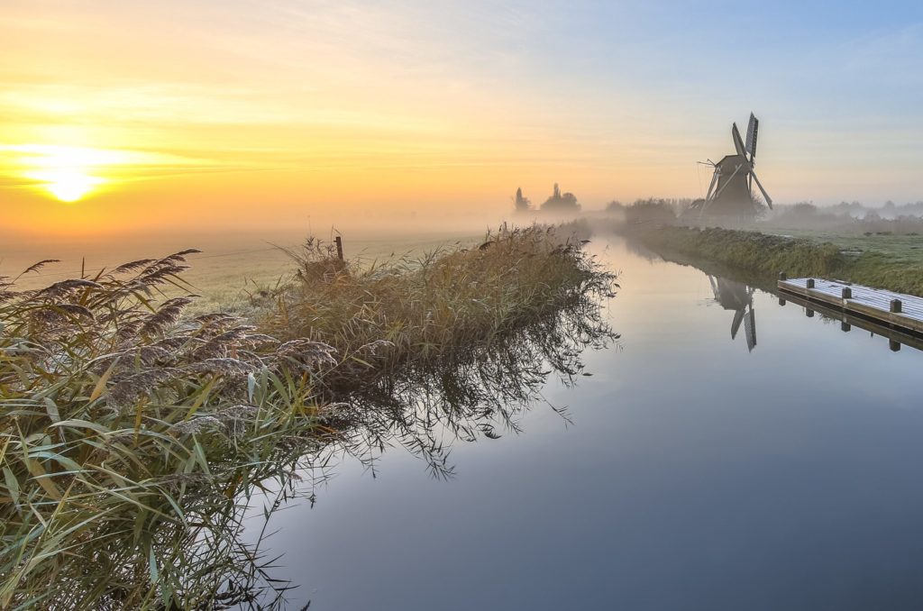 Romantic Dutch countryside in winter - typical polder with a windmill